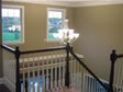 Stair railings on the second floor enhance the “open to below” look from the two-story foyer